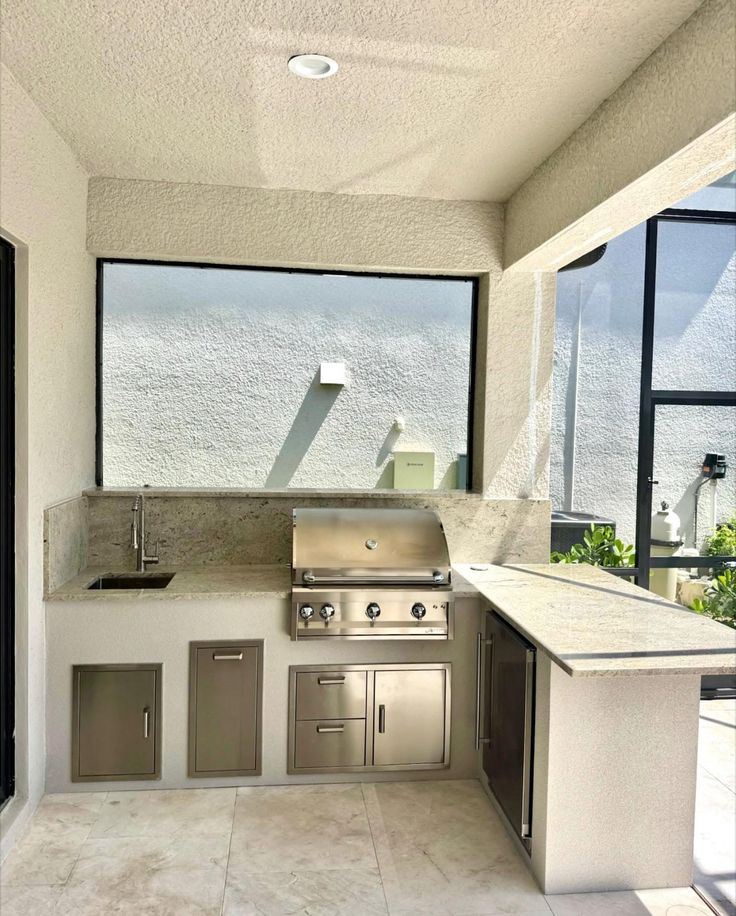 Outdoor kitchen con countertop de granito y grill integrado