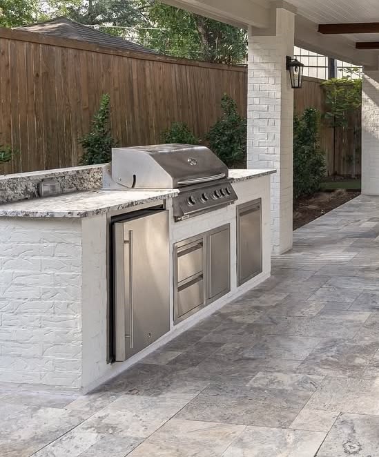 Cocina exterior travertino con grill de acero inoxidable