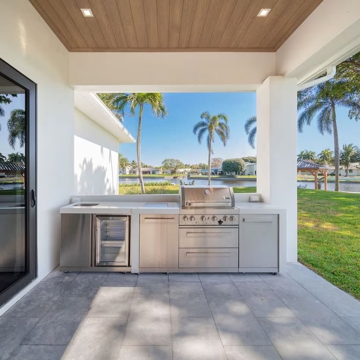 Cocina exterior lineal de acero inoxidable con vista al lago